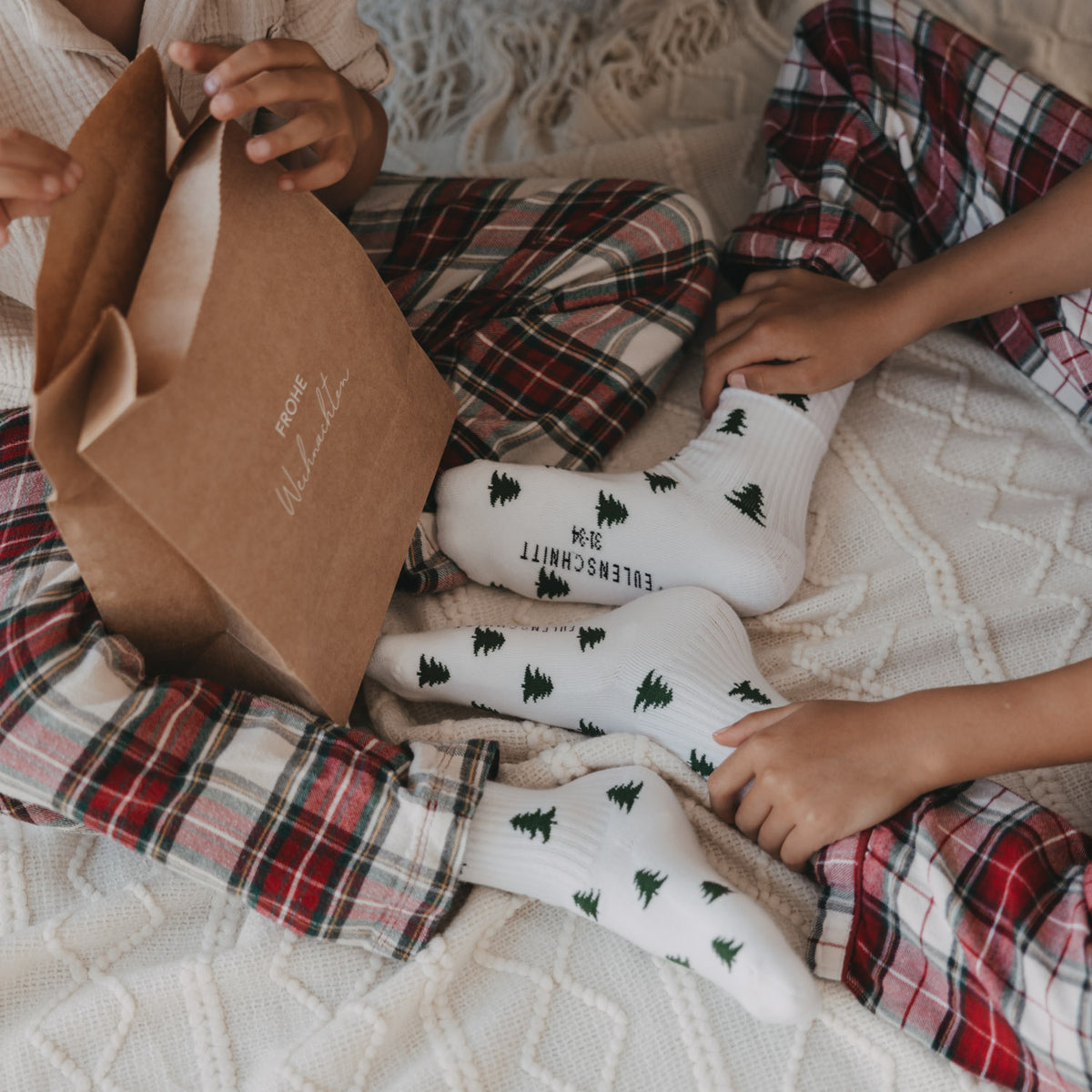 Kindersocken in Weiß mit grünem Tannen-Allovermuster, geripptes Bündchen