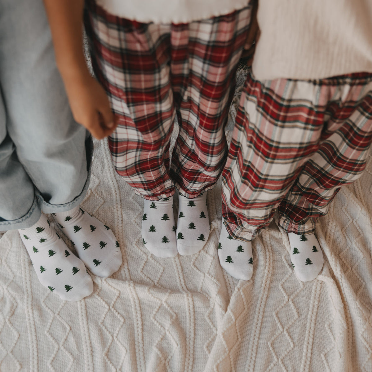 Kindersocken in Weiß mit grünem Tannenmotiv, dreifache Ansicht