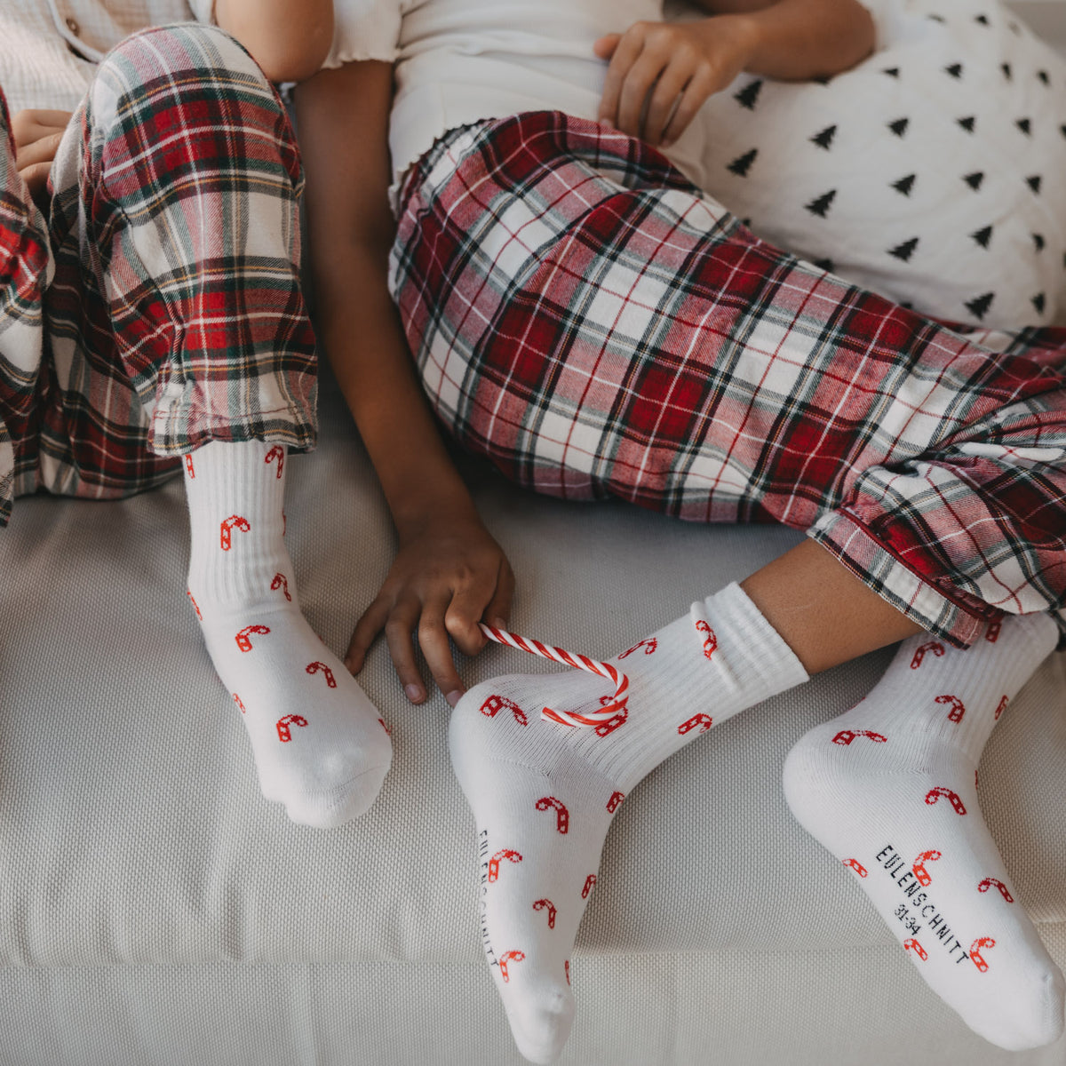 Weiße Kinder-Socken mit rotem Zuckerstangen-Allovermuster, im Set getragen