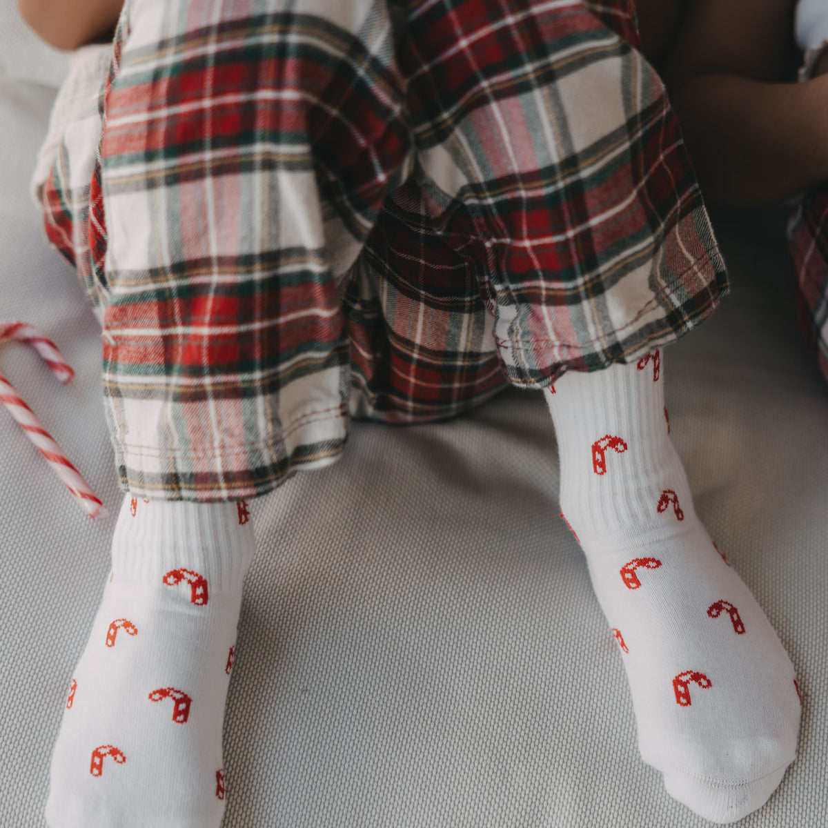 Weiße Kinder-Socken mit rotem Zuckerstangenmuster, Blick auf zwei Socken