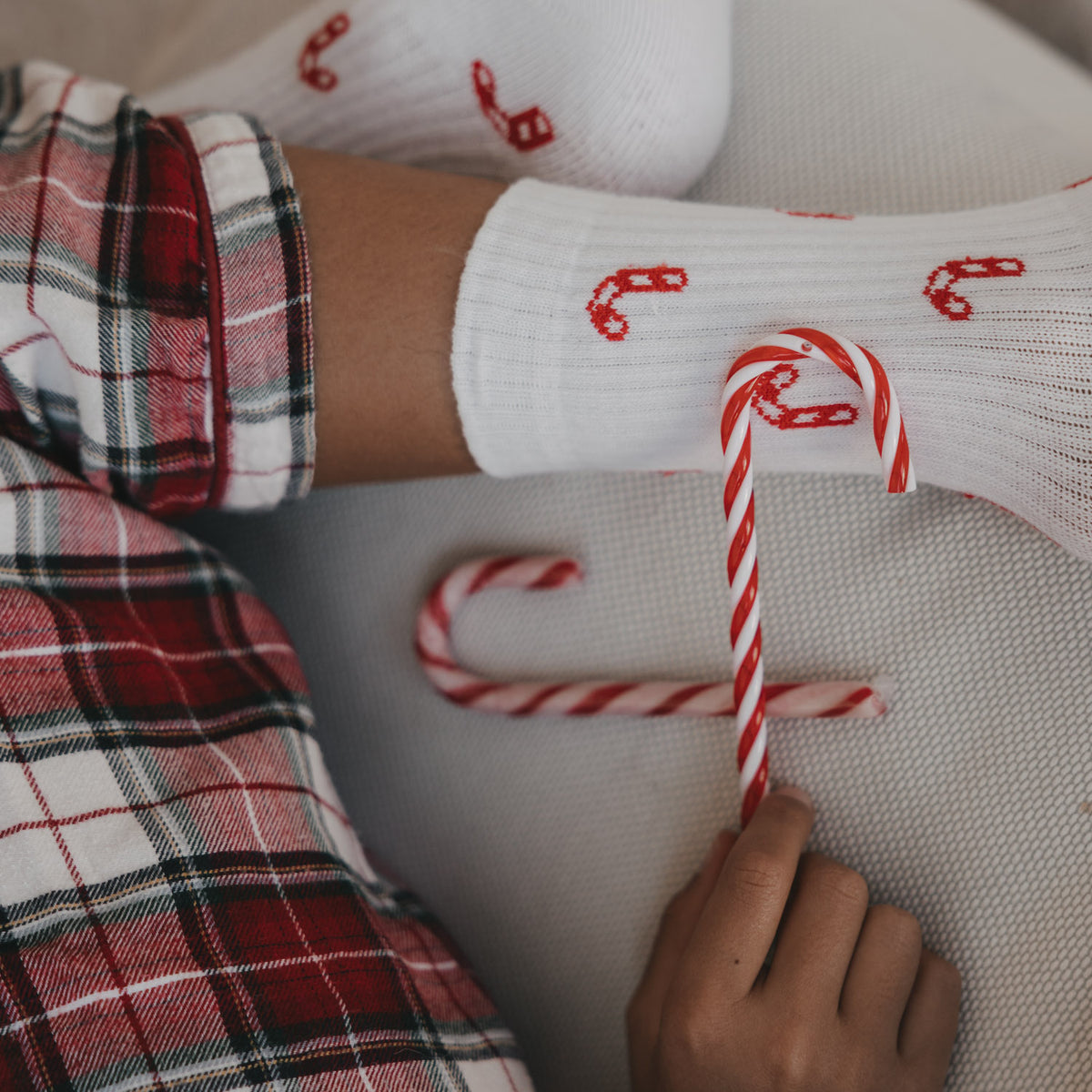 Weiße Kinder-Socken mit rotem Zuckerstangenmuster, Detail am Knöchel und Fuß