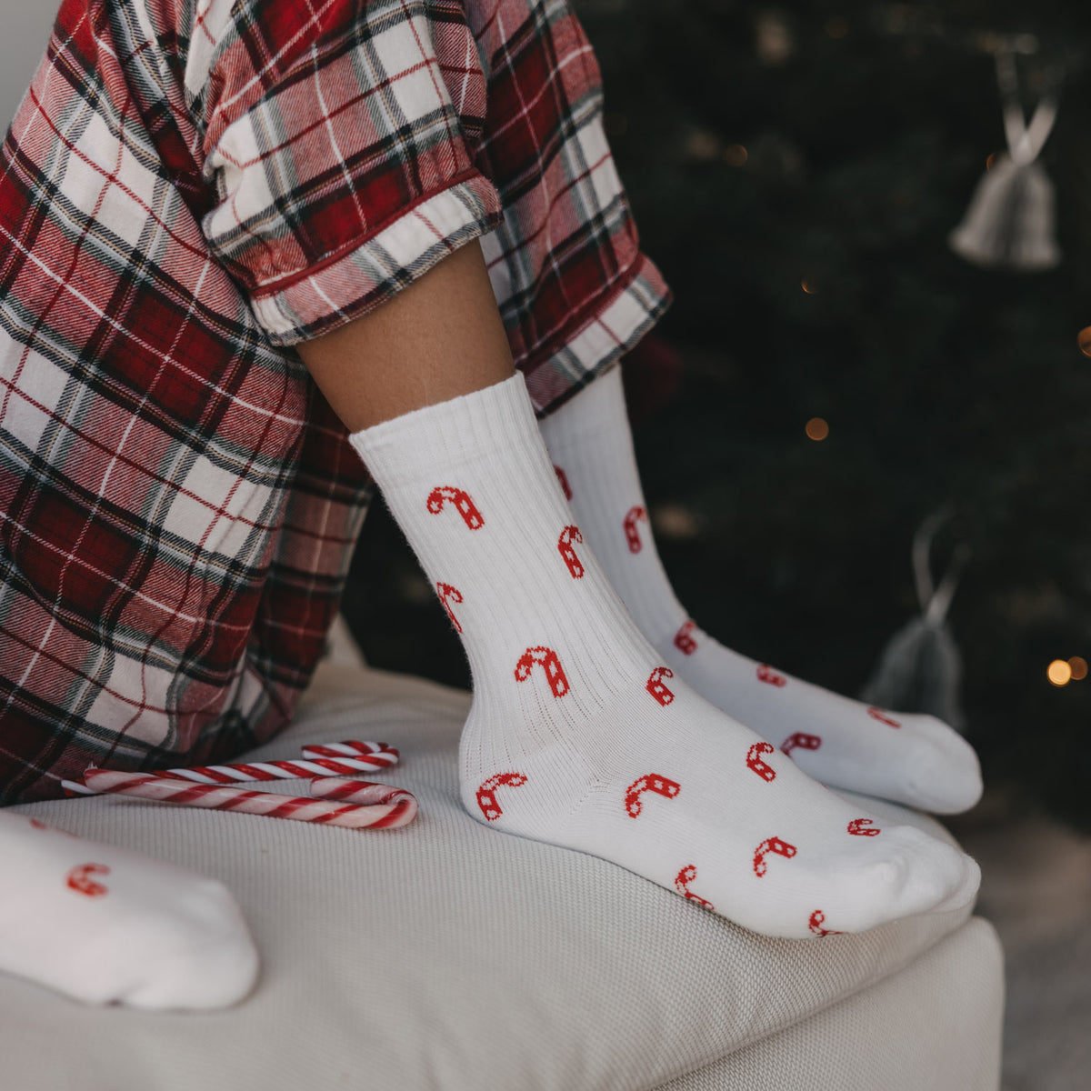 Weiße Kinder-Socken mit rotem Zuckerstangenmuster, seitliche Ansicht von vorn