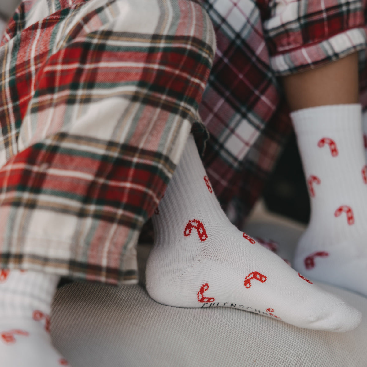 Weiße Kinder-Socken mit rotem Zuckerstangenmuster, Detail am Fuß und Bündchen