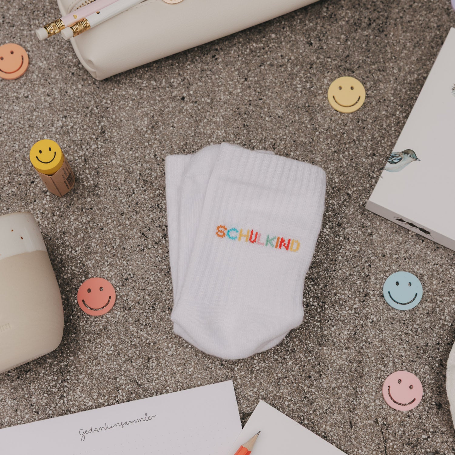 Weiße Kindersocke mit „Schulkind“-Stickerei in der Mitte, gerippter Schaft