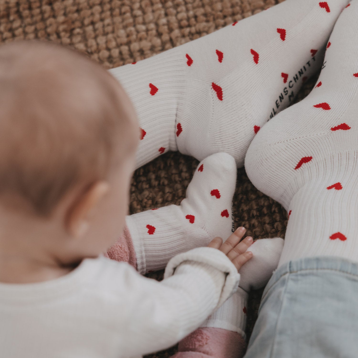 Weiße Babysocken mit roten Herzen, Detail am Schaft und Fersennaht