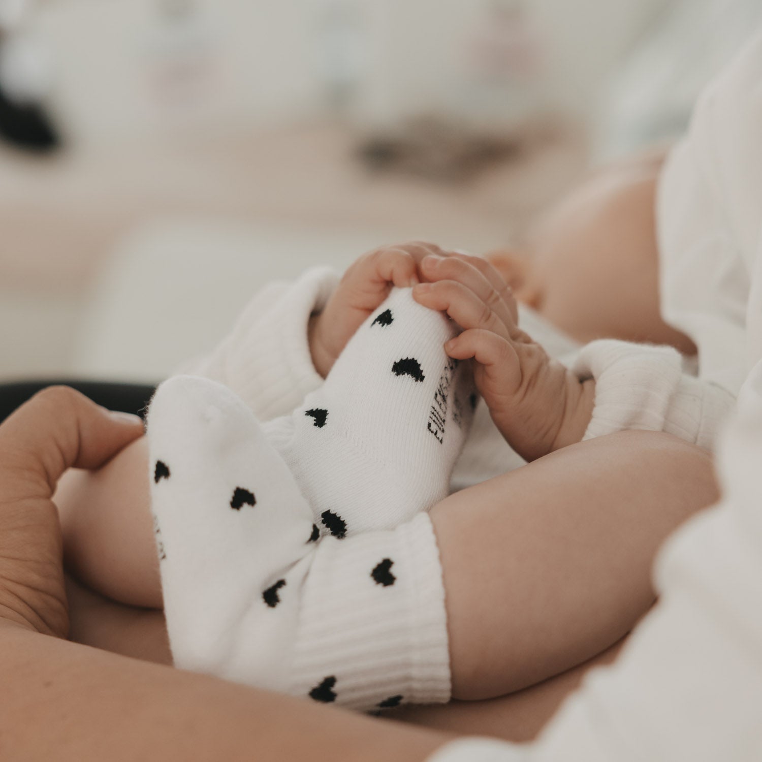 Weiße Babysocken mit schwarzen Herzmotiven, gerippter Bündchenbereich