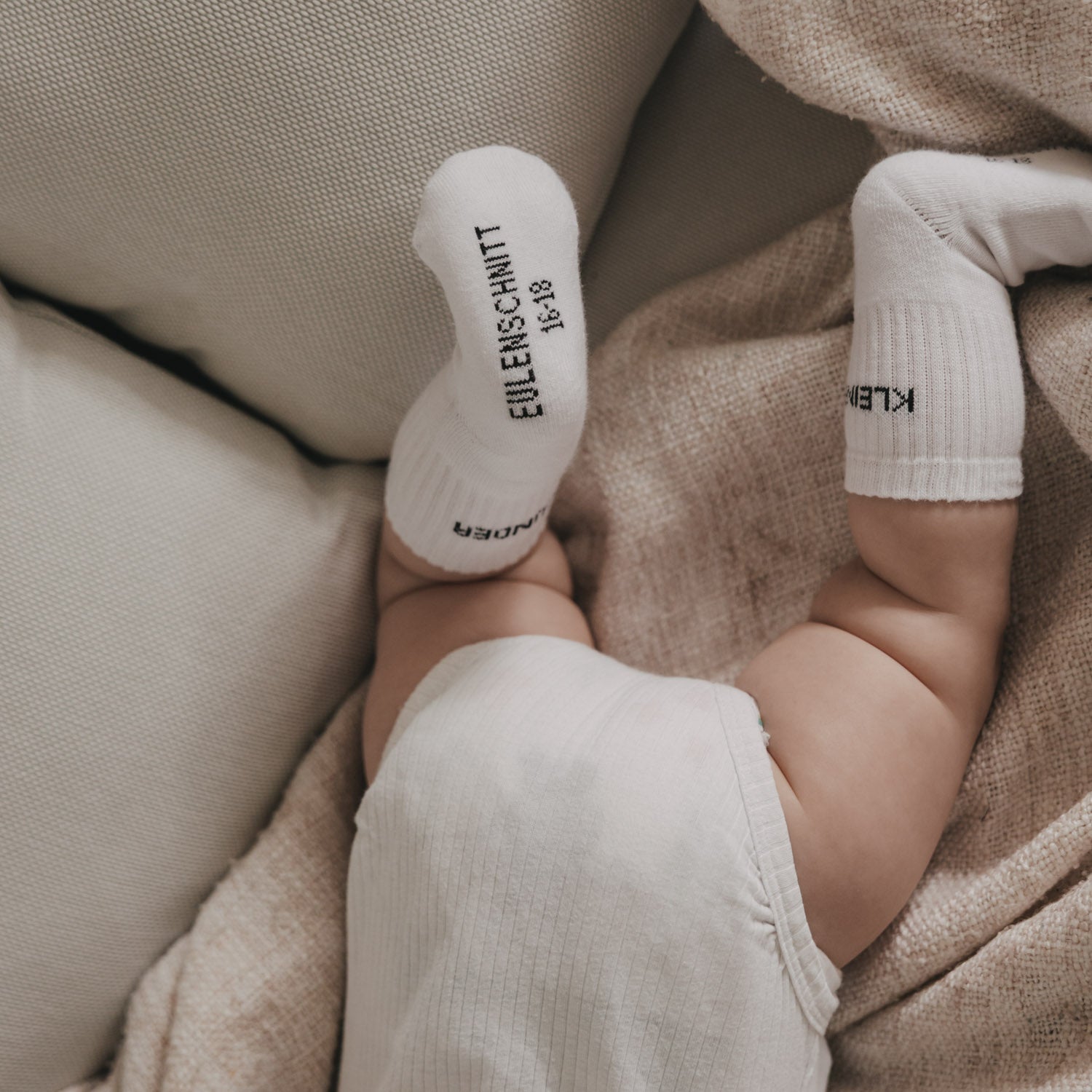 Weiße Babysocken mit weichem Abschluss und eingestrickter Schrift