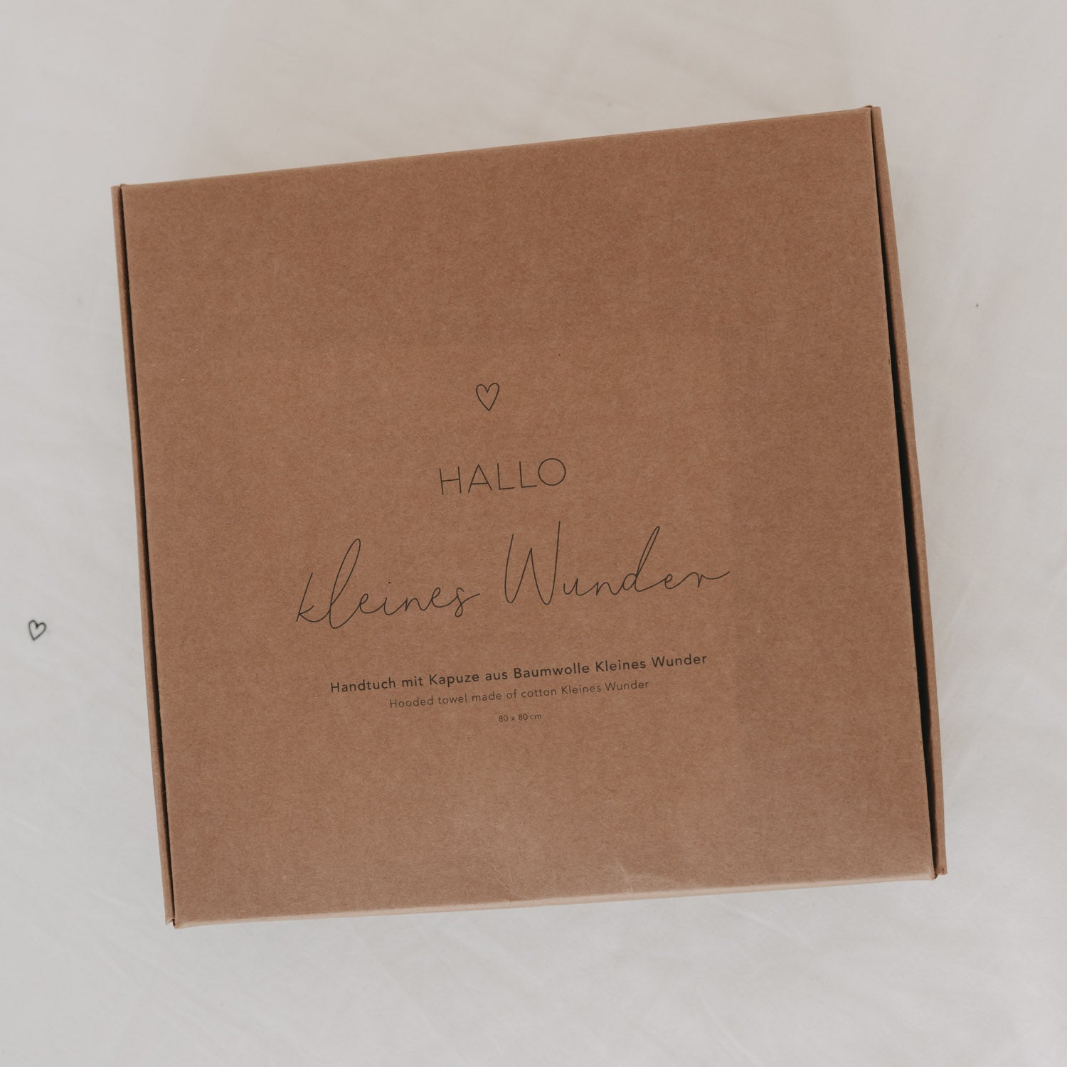 Geschenkbox aus Karton mit Aufdruck „HALLO“ und „Kleines Wunder“