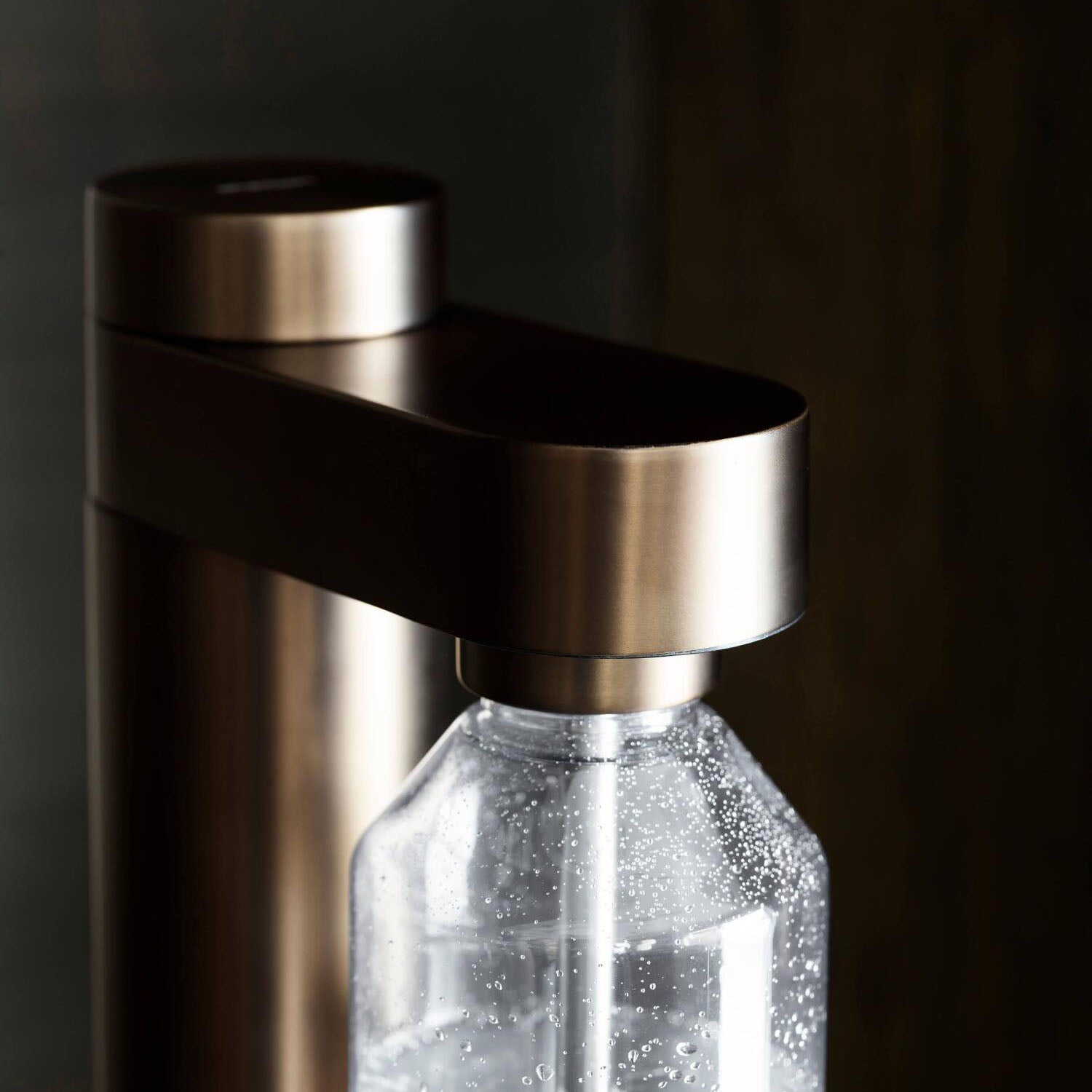 Wassersprudler-Sprudelkopf über Glasflasche mit sprudelnden Bläschen im Inneren