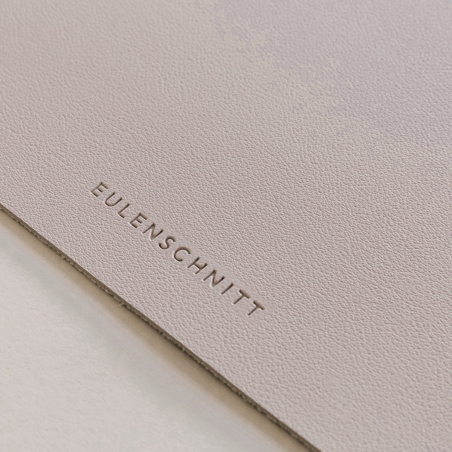 Beige Schreibtischunterlage mit eingeprägter Schrift EULENSCHNITT am Rand