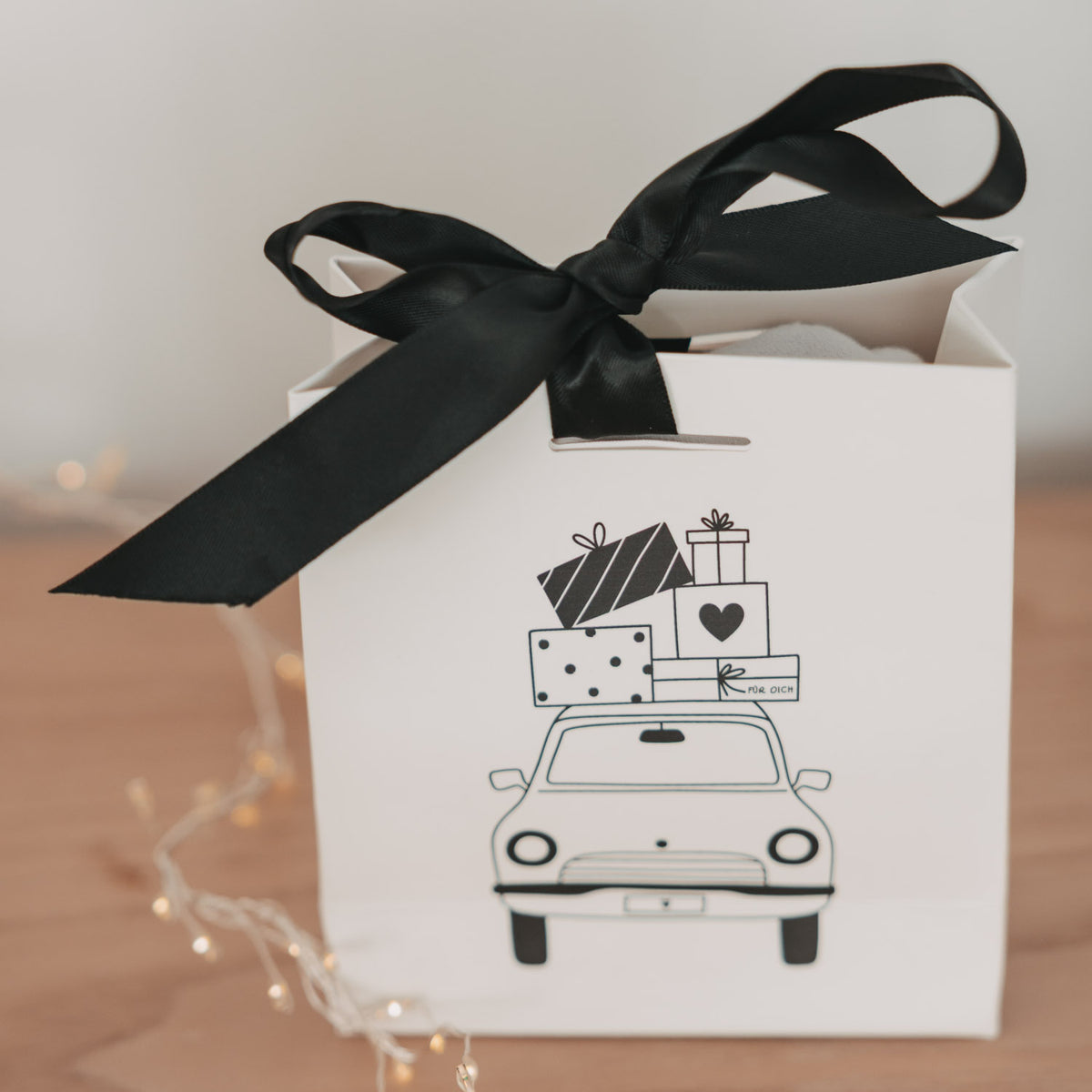 Weiße Mini-Geschenktüte mit schwarzer Schleife und Aufdruck: Auto mit Geschenken