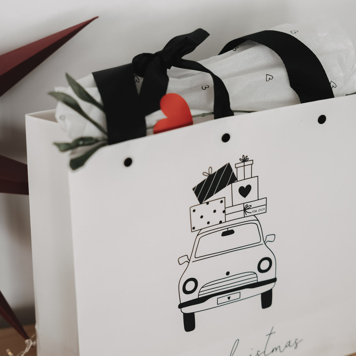 Weiße Geschenktüte (2er-Set) mit schwarzem Henkel, Weihnachtsauto-Print, Inhalt sichtbar