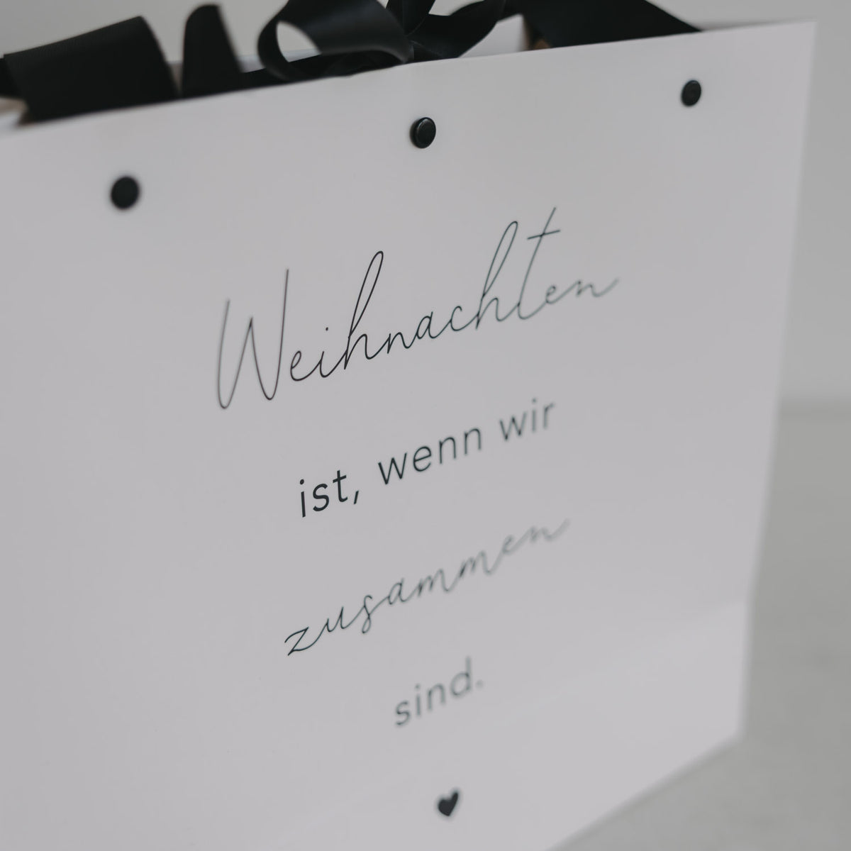 Detail der weißen Geschenktüte: „Weihnachten ist, wenn wir zusammen sind“
