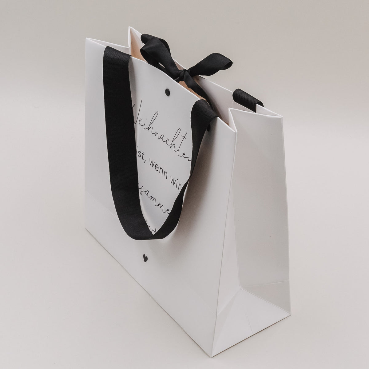 Weißes 2er-Set Geschenktüten mit schwarzen Tragegriffen und Aufdruck „Weihnachten ist…“