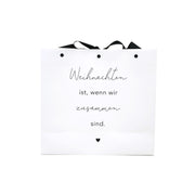 Weiße Geschenktüte mit schwarzem Band, Aufdruck „Weihnachten ist, wenn wir zusammen sind“