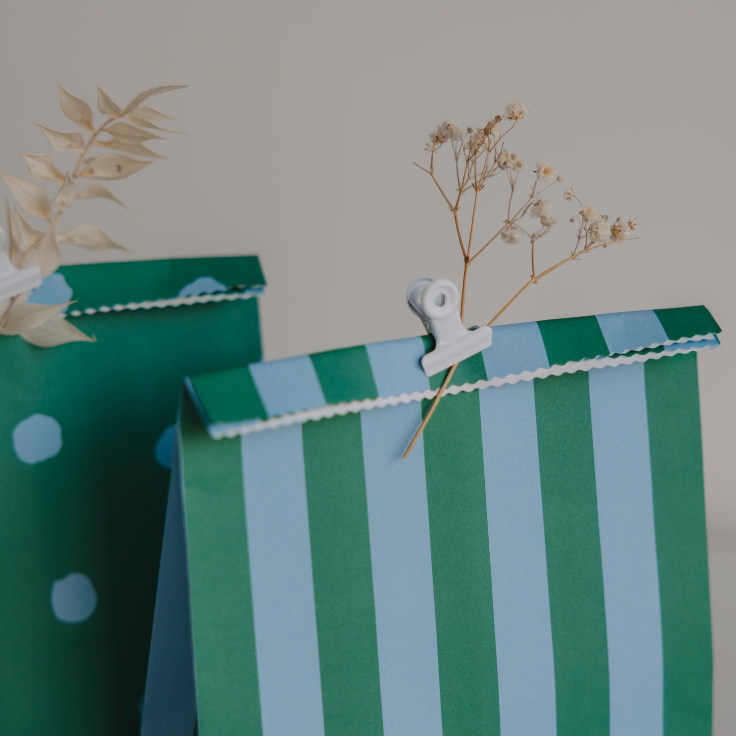 Papiertüten mit blau-grünen Streifen und Punkten, oben mit Wellenrand