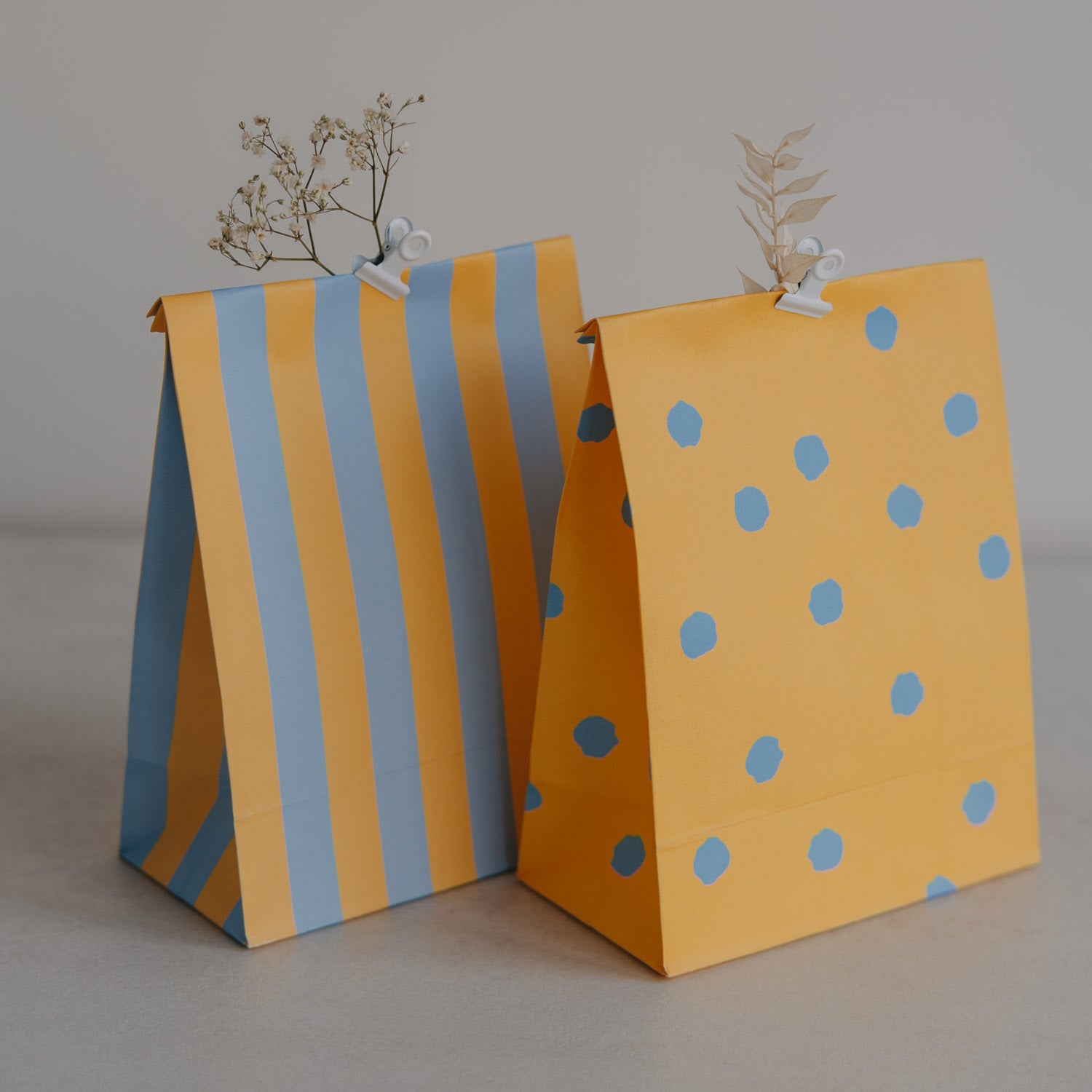 Papiertüte aus Papier: gelb-blau gestreift und gelb mit blauen Punkten