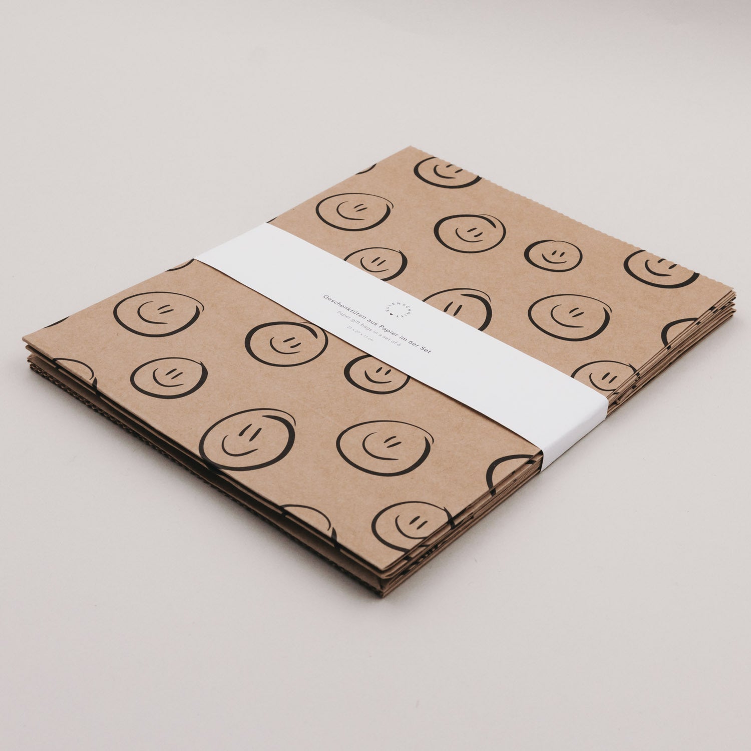 Papiertüten-Set gestapelt, Smiley-Muster auf dem Papier, Sicht auf die Papierlaschen