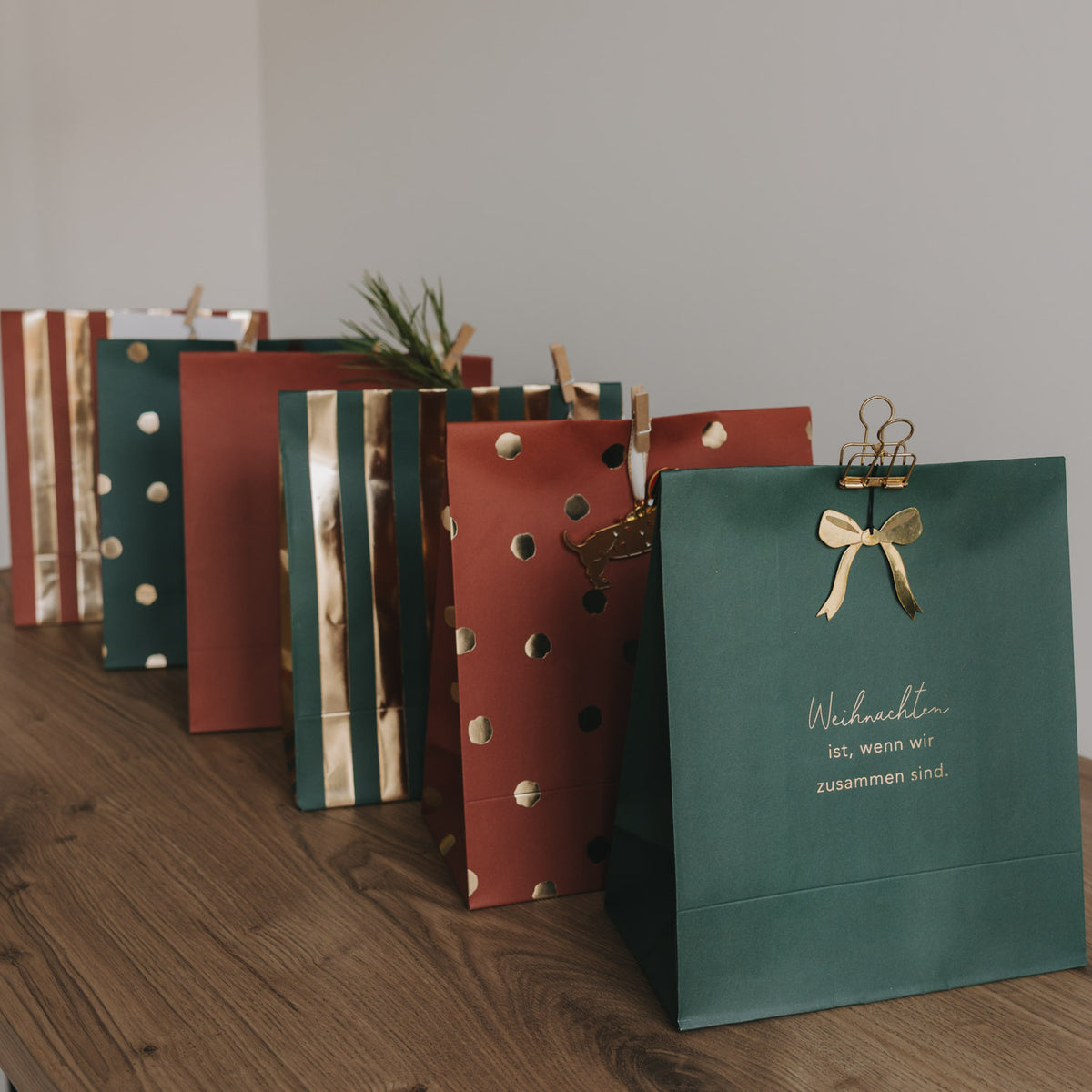Grüne Weihnachtspapiertüte mit Aufdruck „Weihnachten ... zusammen sind“ und Bandgriff