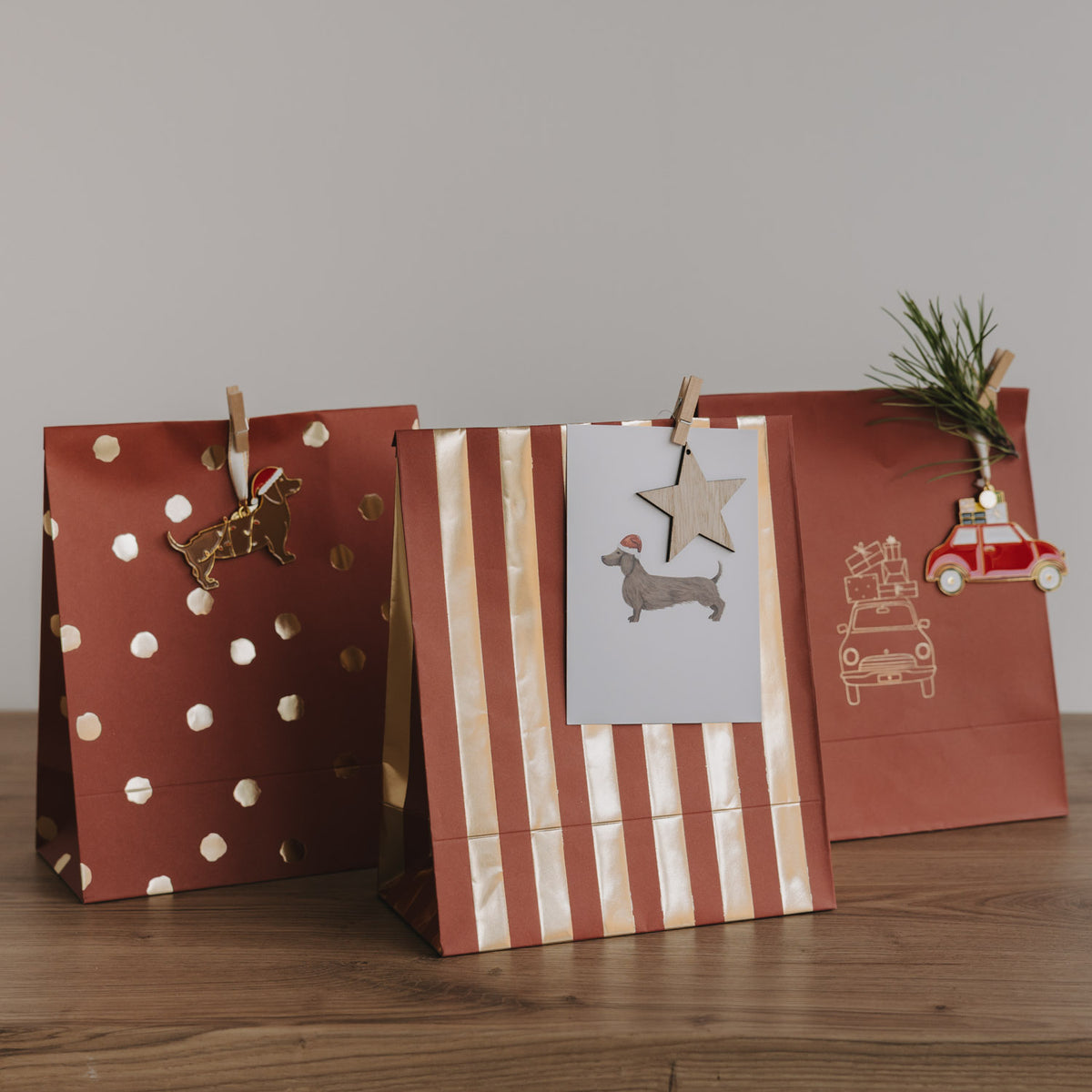 Drei Papiertüten für Weihnachten in Rot: gestreift, gepunktet und mit Fahrzeug-Motiv
