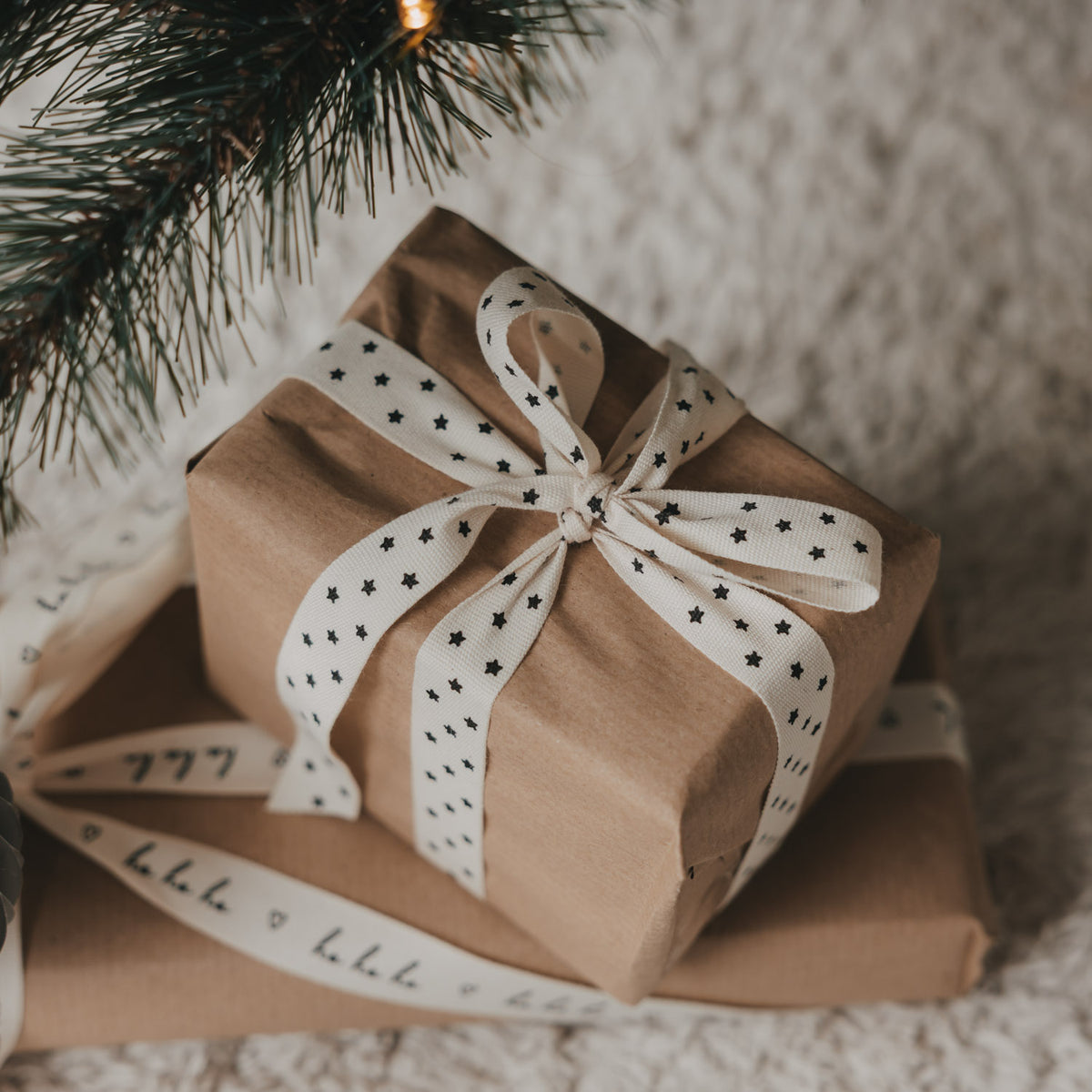 Geschenkband mit Sternen, zu Schleife gebunden auf braunem Geschenk verpackt