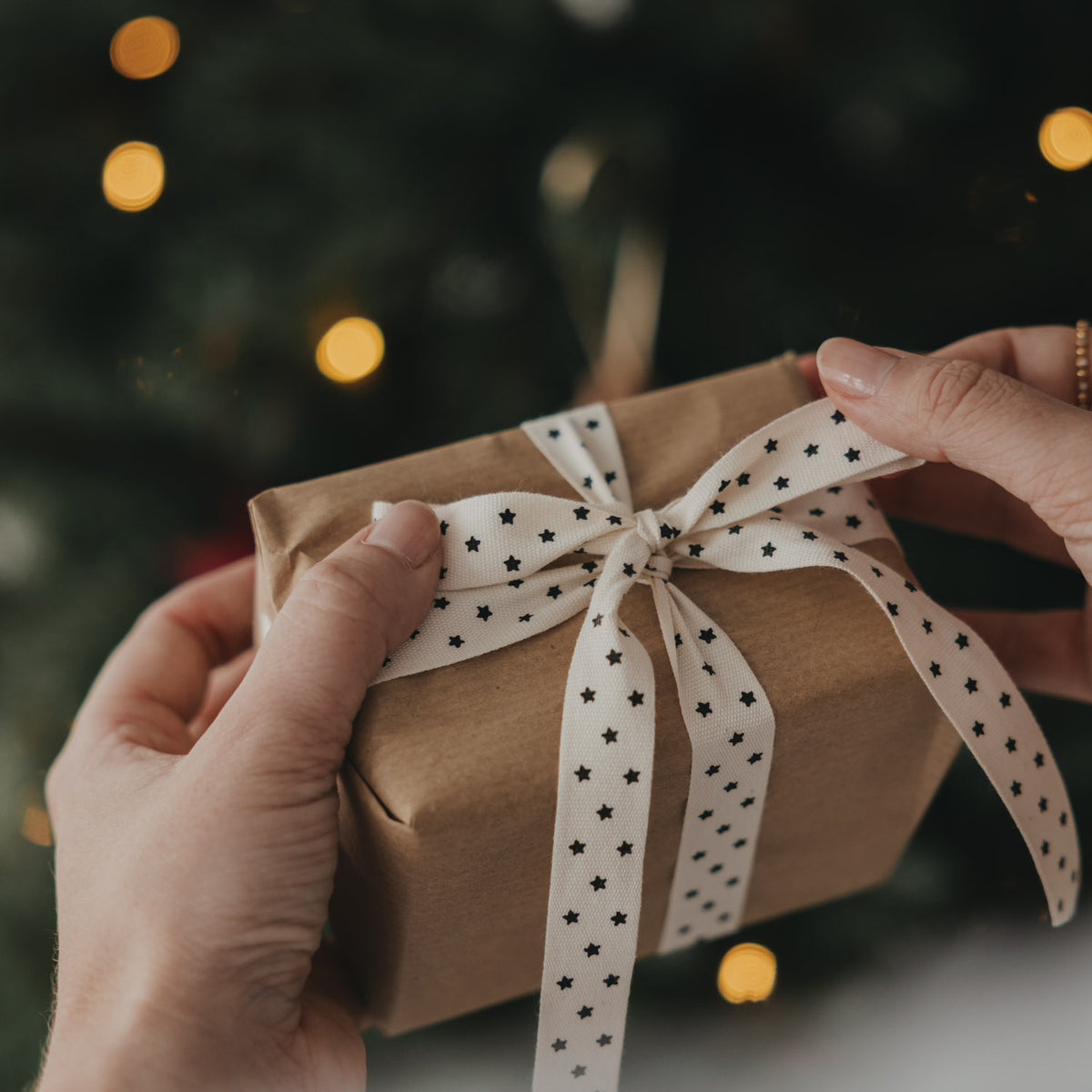 Sterngemustertes Geschenkband mit Sternen, Schleife gebunden auf braunem Geschenk